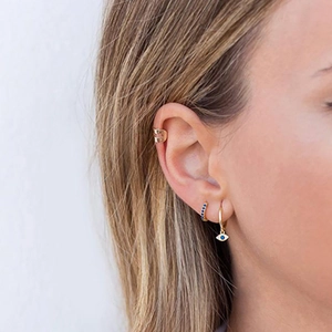 Boucles d'oreilles œil protecteur en argent S925 et manchette dorée sur modèle