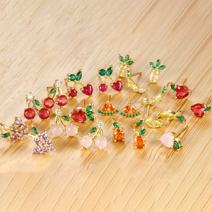 Macro shot of colorful zircon fruit stud earrings including cherry and strawberry designs