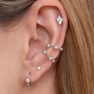 Close-up of minimalist silver ear cuffs and studs set with white cubic zirconia