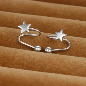 Silver star ear cuffs with curved metal rods and ball charms on a brown velvet tray