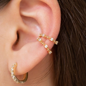 Minimalist gold ear cuff and earring set with cubic zirconia stones on model's ear