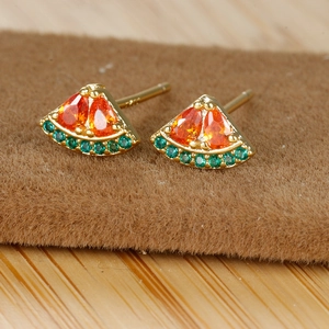 Macro shot of 18K gold watermelon stud earrings with orange and green sparkling zircons