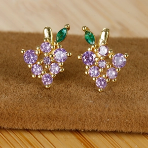 Macro detail of grape-shaped stud earring with purple zircon stones and green leaf