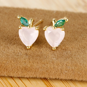 Macro shot of 18K gold-plated peach stud earrings with heart pink zircon and green leaf