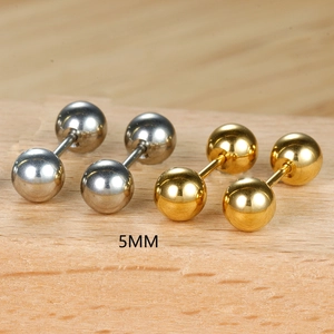 Détail des boucles d'oreilles boules de 5mm en or et argent sur un support en bois