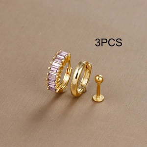Detailed shot of 3-piece gold jewelry set with purple zircon earring and labret stud