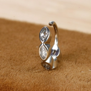 Macro-opname van drie marquise-zirkonia op een gepolijste zilveren navel piercing ring