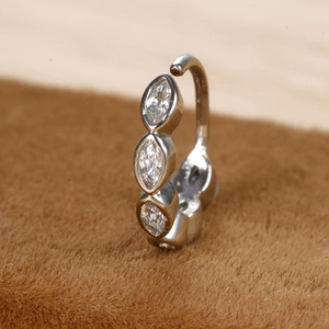 Detail van de zilveren piercingring met drie marquise-zirkonia's op een bonten ondergrond