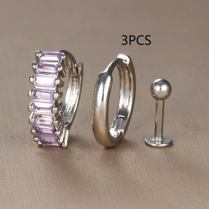Detail of 3-piece silver earring set with baguette purple zircon hoop and stud earrings
