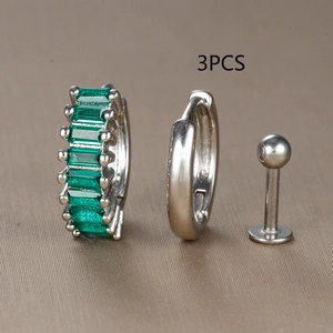 Detail of 3-piece silver earring set featuring an emerald green zircon hoop and studs