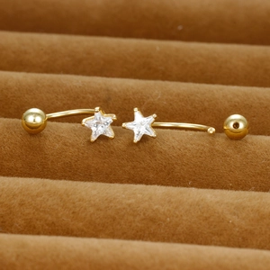 Sternförmiges, goldenes, gebogenes Barbell-Piercing mit klarem Zirkon auf braunem Samt