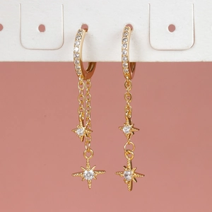 Elegante 18K vergulde kettingoorbellen met zirkonia sterren op een roze achtergrond