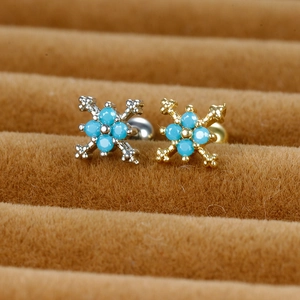 Cross stud earrings with blue turquoise stones in gold and silver finish on display