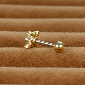 Macro detail of a barbell cartilage stud featuring a gold starburst with blue turquoise inlay