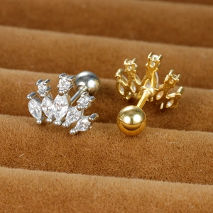 Macro shot of sparkling zircon crown cartilage earrings with screw back balls in gold and silver