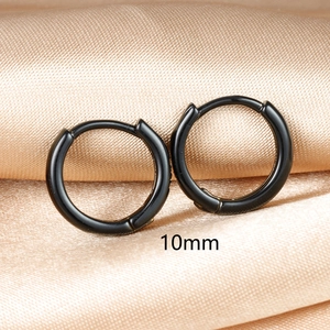 Makro-Detail von schwarzen 10mm Creolen auf hochwertigem champagnerfarbenem Seidenstoff