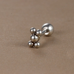 Gros plan sur un clou d'oreille en acier inoxydable argenté avec grappe de boules