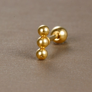 Vue détaillée du piercing en acier doré à trois billes avec fermeture à bille vissée