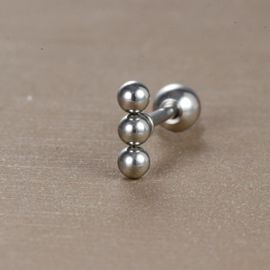 Vue macro d'un piercing en acier chirurgical à trois boules polies avec fermoir à vis