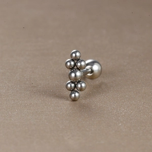 Vue macro de boucles d'oreilles géométriques en acier avec fermoir à vis sécurisé