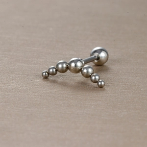 Détail macro d'un piercing incurvé en acier inoxydable avec sept billes argentées