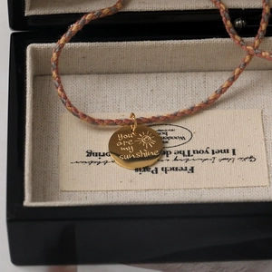 Braided three-color cord necklace with gold sun pendant engraved You Are My Sunshine