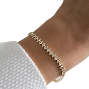 Bracciale minimalista placcato oro 18K con zirconi taglio marquise sul polso di una modella