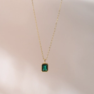 Detailed macro of vintage emerald green rectangular pendant with 18k gold-plated chain