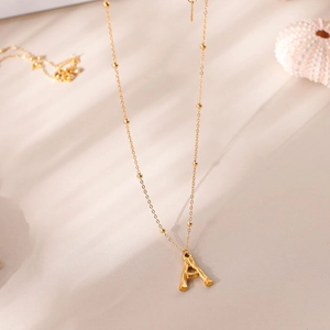 Détail du pendentif lettre A plaqué or 18 carats sur une fine chaîne perlée