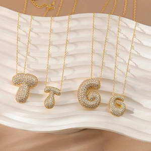 Ketting met letterhangers van zirkonia en gouden ketting met T en G bubble bedeltjes