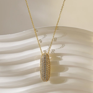 Detail van de gouden ovale hanger met micro-pave witte zirkoon op een fijne ketting