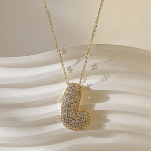 Detail van de goudkleurige bubble letter J hanger met glanzende strass op de ketting