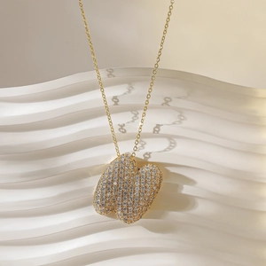 Detailopname van een 18K gouden halsketting met abstracte harthanger en pavé diamanten