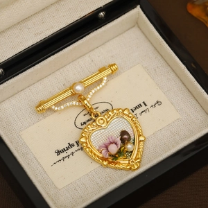 Broche vintage en or avec pendentif cœur, fleurs et perles dans un coffret cadeau noir