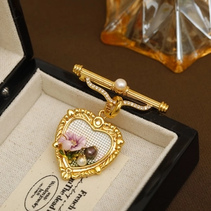 Broche cœur vintage avec fleurs en émail et perles sur une monture en métal doré