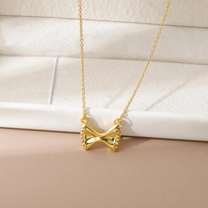 Elegante 18K vergulde strik hanger ketting met 3D textuur op een wit sieradendoosje