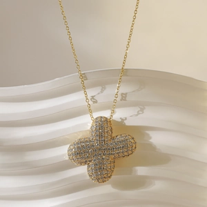 Detailopname van een gouden klaverhanger met schitterende zirkonia kristallen