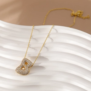 Macro-opname van gouden letter B hanger ketting met zirkonia op witte golvende display