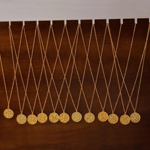 Vintage gouden kettingen met bloemgravures op ronde hangers op een rij