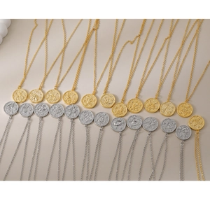 Gouden en zilveren kettingen met bloemenreliëf en ronde matte muntvormige hangers