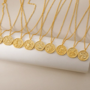 Gouden muntkettingen met geboortebloem gravures op een witte standaard