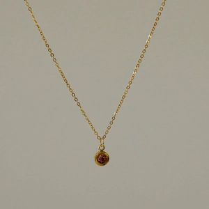 Nahaufnahme einer 18k vergoldeten Edelstahlkette mit rosa rundem Zirkonia-Anhänger