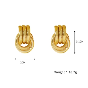 Macro detail of chunky gold triple-layered geometric hoop earrings with high-polished finish
