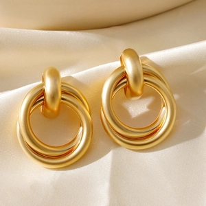 Minimalist 18K gold-plated interlocking double hoop earrings on silk background