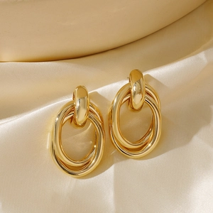 Detailed macro view of 18K gold plated triple layered intertwined geometric stud earrings