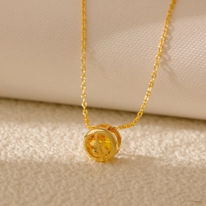 Macro shot of gold-plated zodiac pendant with yellow zircon and hollow cross design