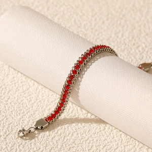 Detail of a double-layered stainless steel bracelet with red cubic zirconia and lobster clasp