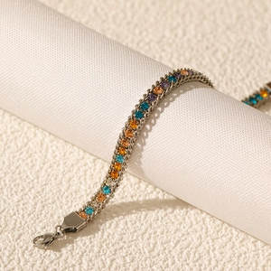 Detail of multi-colored zircon stones set in a stainless steel bracelet with lobster clasp