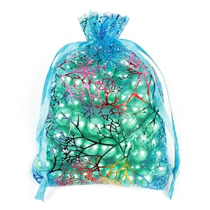 Vista macro detallada de la bolsa de regalo de organza azul con patrón de coral metálico