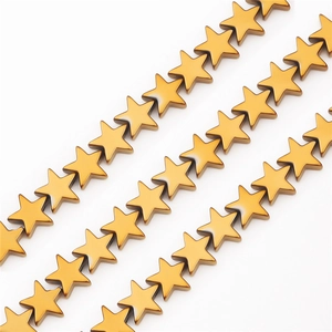 Makroaufnahme von vergoldeten Sternperlen mit glänzendem Metallfinish für DIY-Schmuck